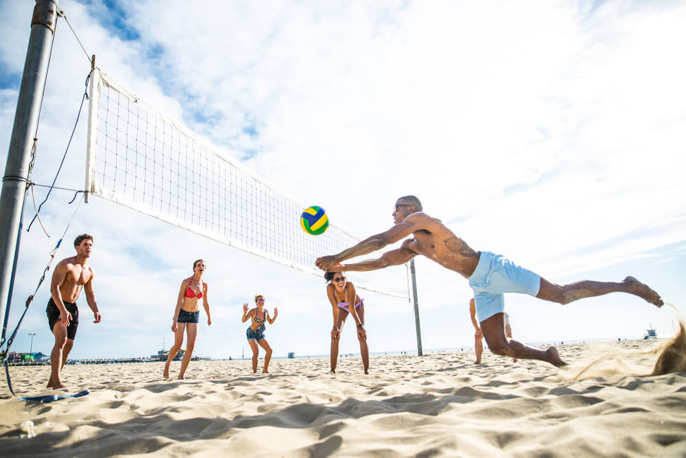 Man diving for ball during sand volleyball game with friends (1)