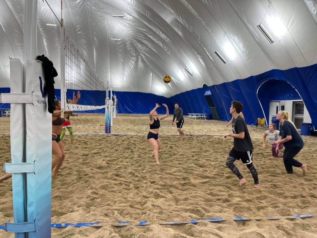 Sand volleyball team playing on an indoor court