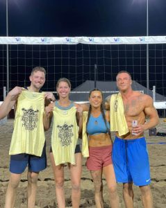 Sand volleyball team holding up shirts What to wear when playing sand volleyball