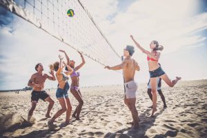 Friends playing sand volleyball