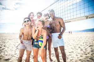 Group of friends playing sand volleyball