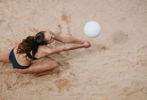 Player passing a volleyball on a sand court