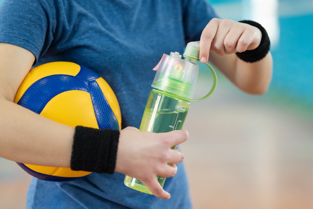 Volleyball essentials: a volleyball, water bottle, and attire