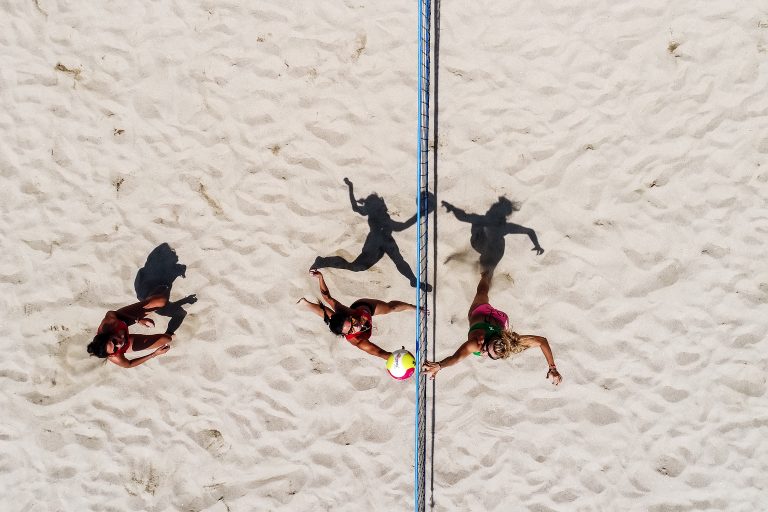 Overhead view of a women’s sand volleyball match with players on court in Ozark, MO